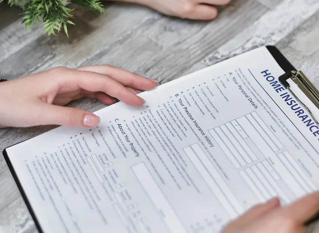 Close-up of hands holding a home insurance document indoors, showing personal details section. Hvilke krav stiller GDPR til små virksomheder?